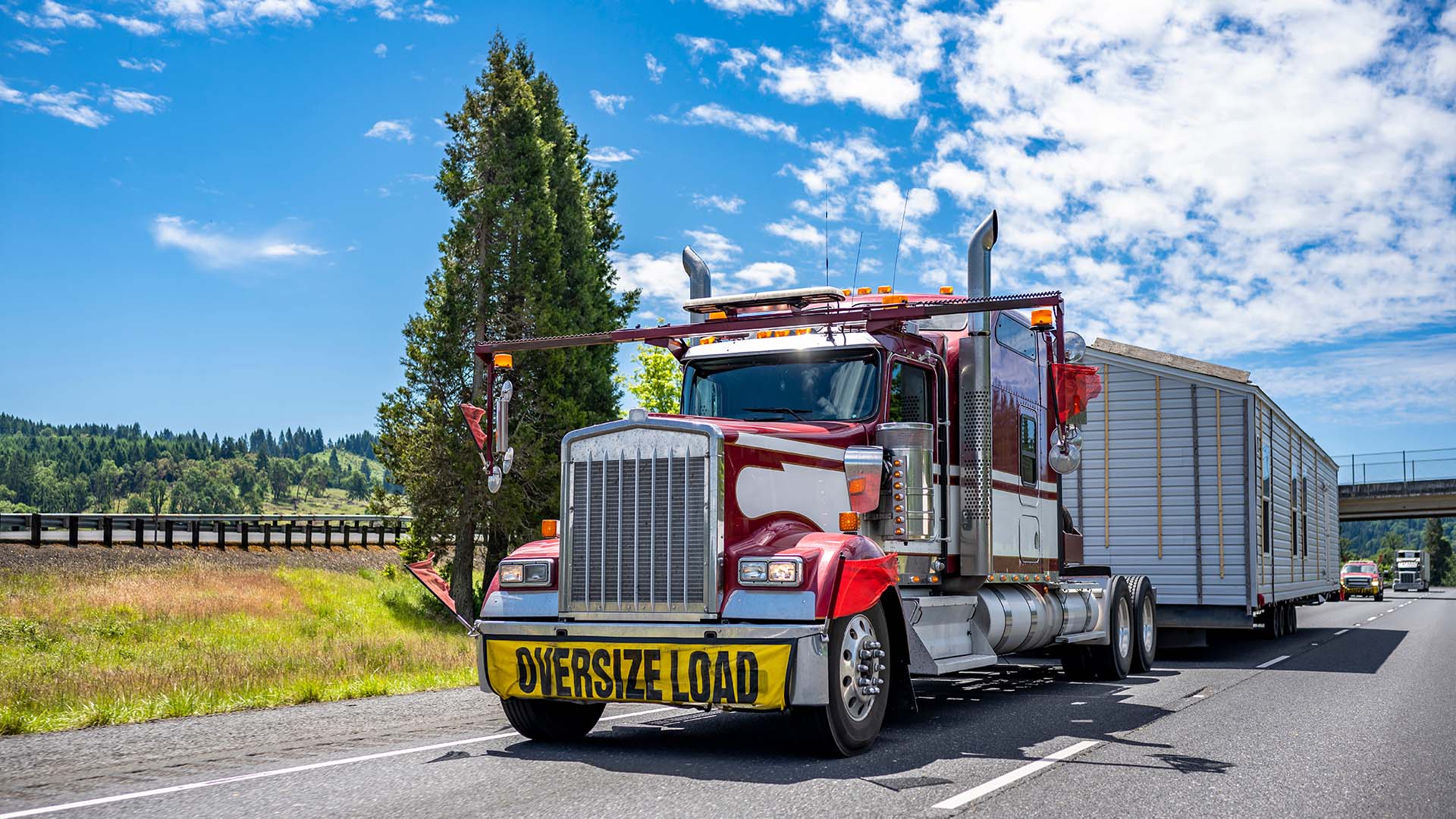 Oversize load semi truck hauling a large modular building on a public highway